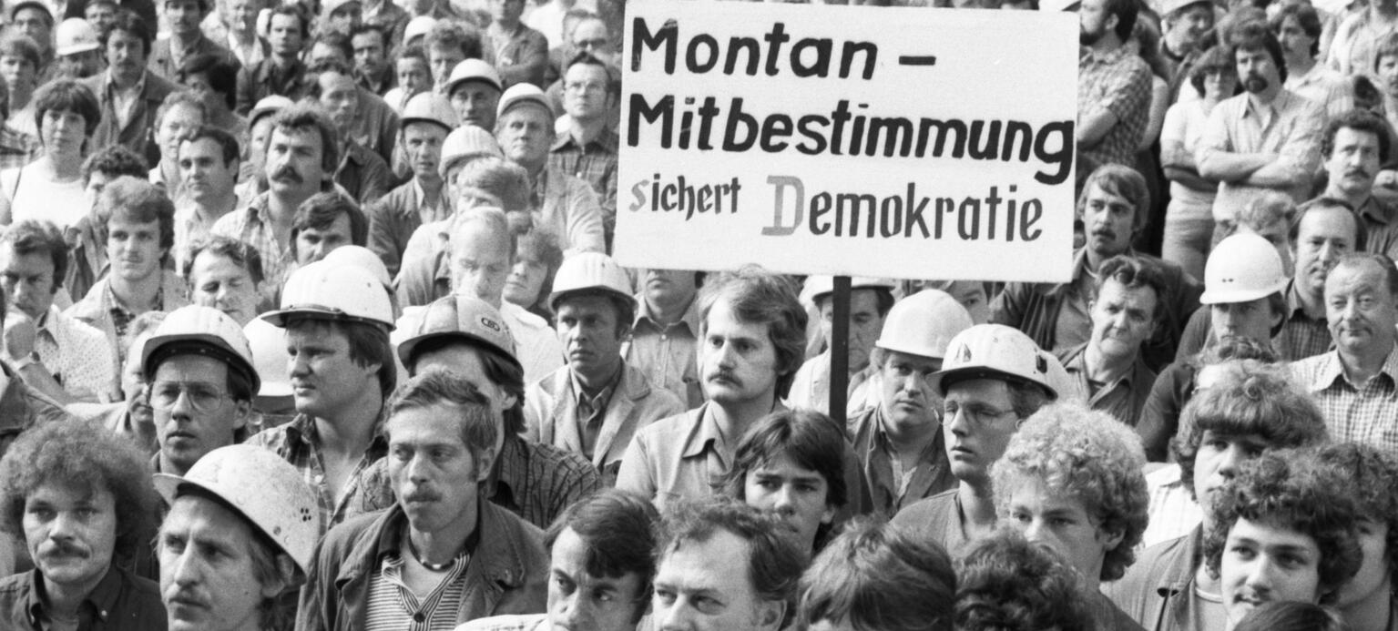 Demonstrant hält ein Schild hoch in einer großen Menschenmenge