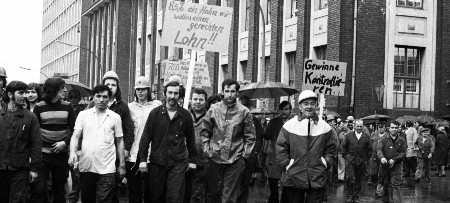 Demonstrierende Arbeiter vor Fabrikgebäude in den 70-iger Jahren